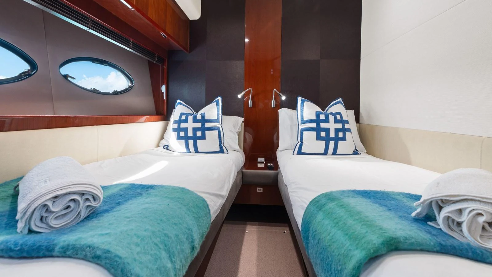 The twin stateroom offers a cozy and elegant space with two single beds adorned with plush pillows and blankets. aboard ABOUT TIME Yacht for Sale