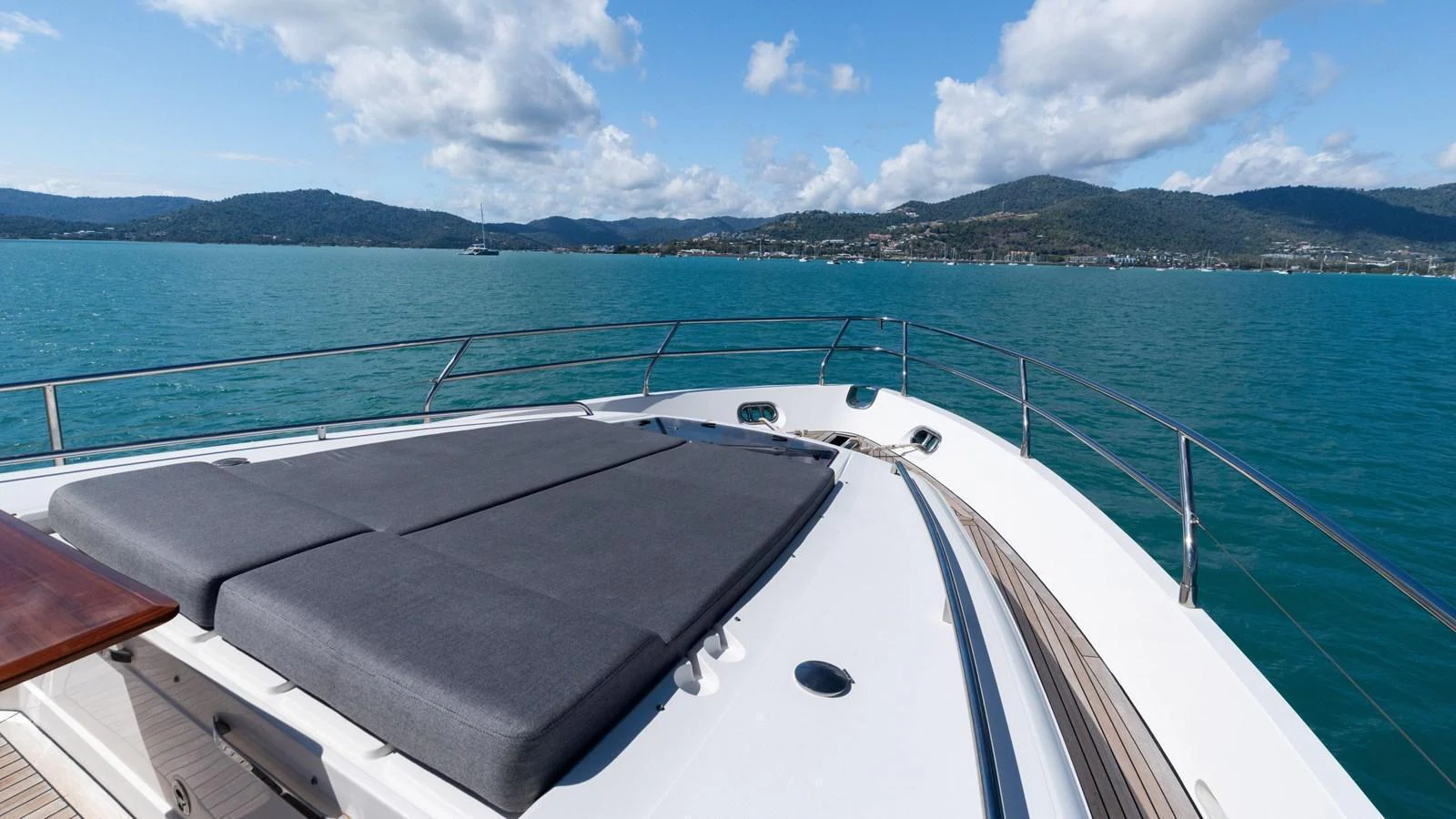 The yacht's foredeck features a spacious sunbathing area with luxurious cushions, offering stunning views of the surrounding waters. aboard ABOUT TIME Yacht for Sale