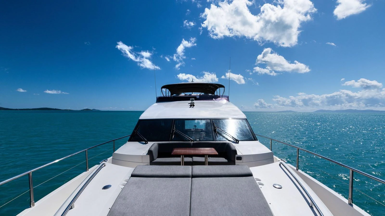 The yacht's bow area features a spacious sunpad with stunning ocean views. aboard ABOUT TIME Yacht for Sale