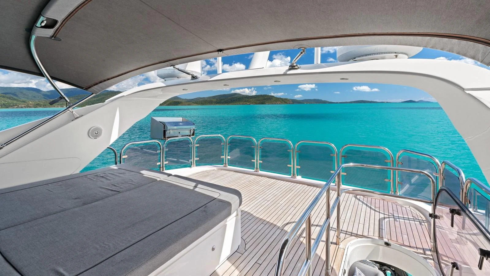 The yacht's aft deck offers a serene view of turquoise waters and distant islands, perfect for relaxation. aboard ABOUT TIME Yacht for Sale