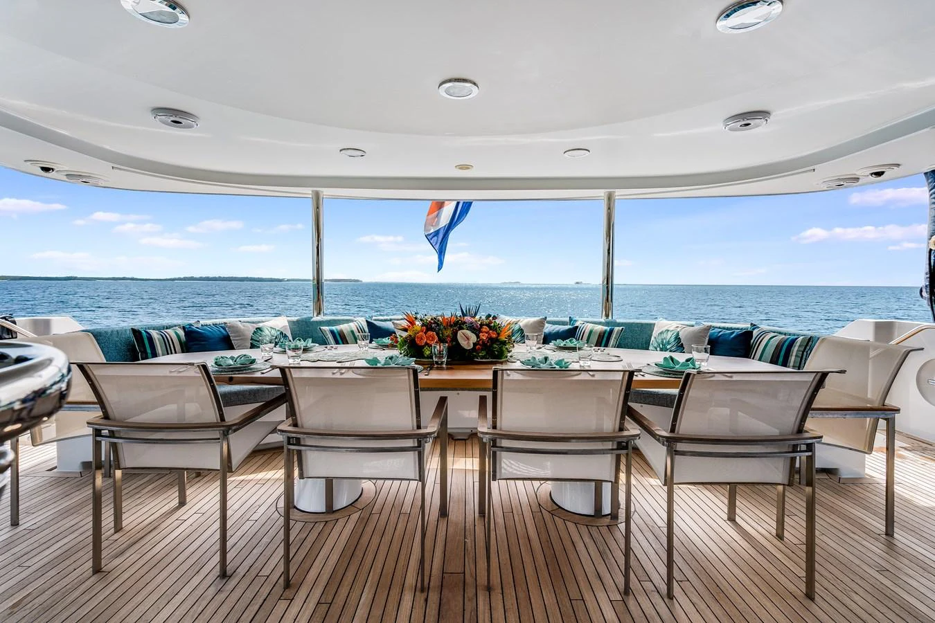 a table with chairs and a large body of water in the background aboard CUPCAKE Yacht for Sale