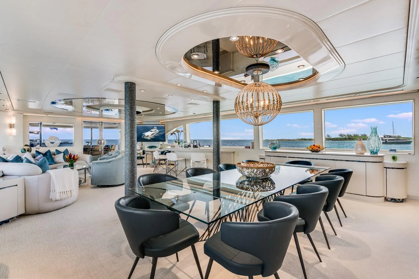 a room with a table chairs and a chandelier aboard CUPCAKE Yacht for Sale