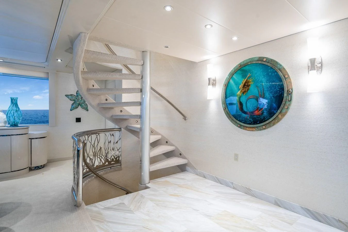 a white room with a staircase and a white wall and a blue globe aboard CUPCAKE Yacht for Sale