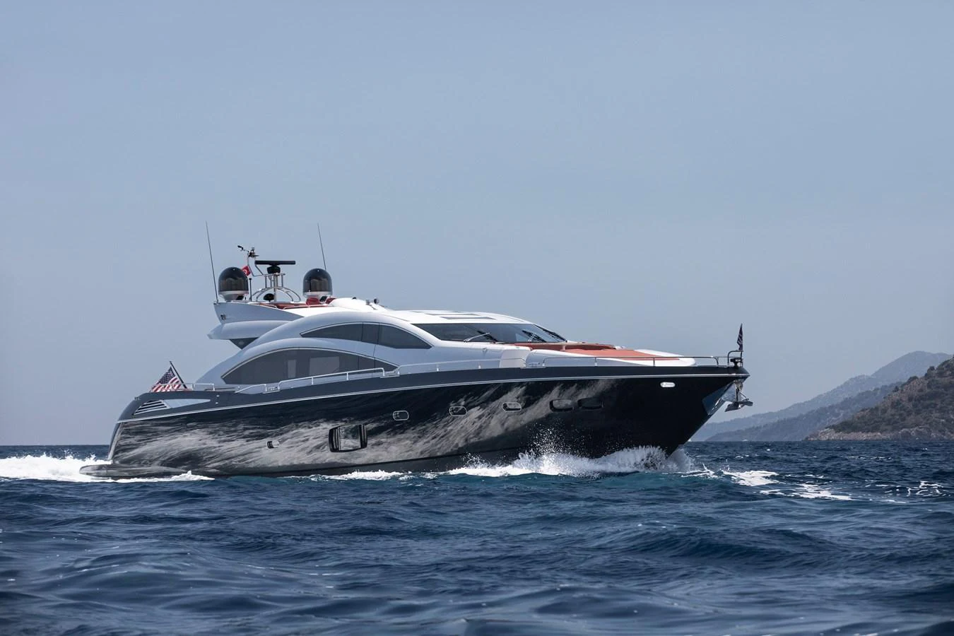A sleek and modern yacht cruises on the open water under a clear sky. aboard AMARA Yacht for Sale