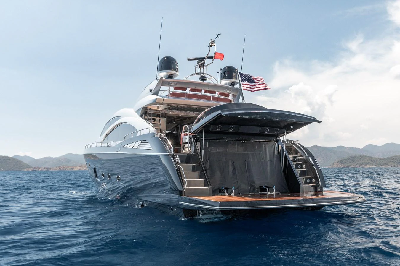 A sleek yacht cruising on open waters with a partially open aft deck. aboard AMARA Yacht for Sale