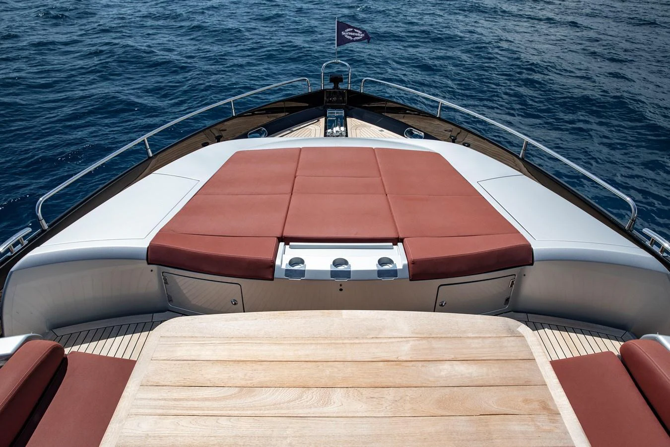 The foredeck features a spacious sunbathing area with plush cushions and a teak table, perfect for relaxation. aboard AMARA Yacht for Sale