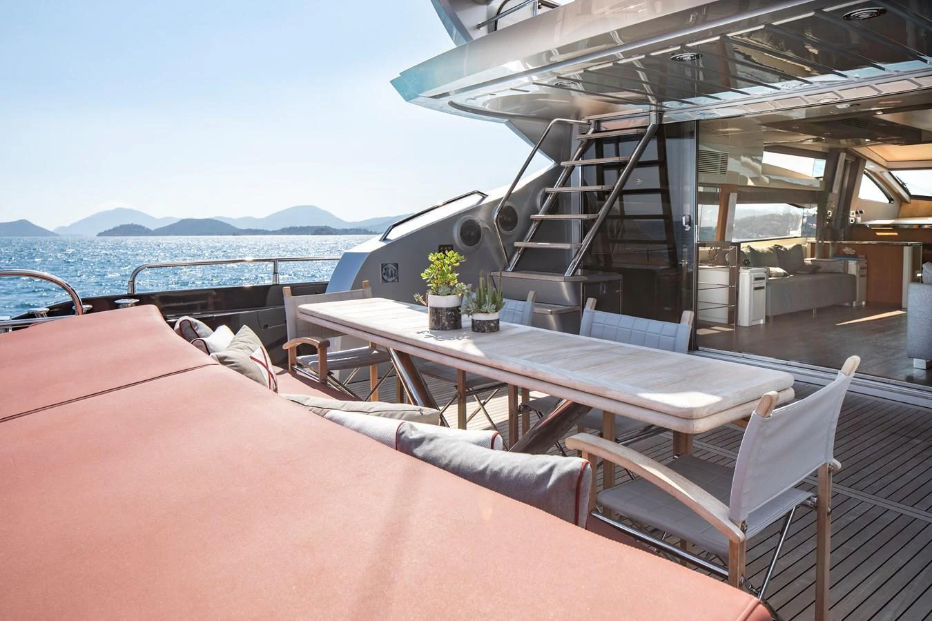 The aft deck features a spacious dining area with a large table and comfortable seating, perfect for al fresco meals with a view of the sea. aboard AMARA Yacht for Sale
