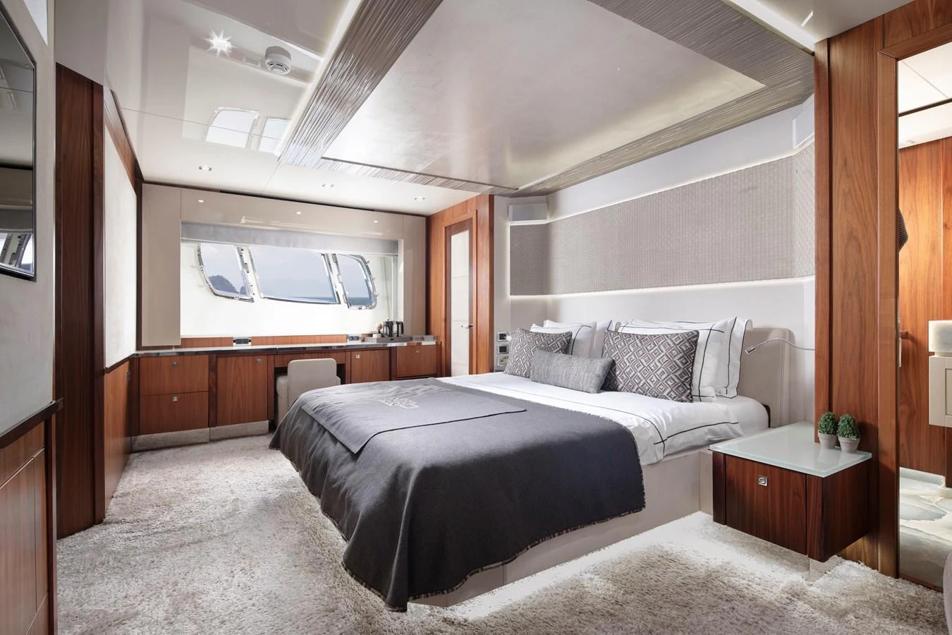 The master stateroom features a spacious bed, elegant wood finishes, and ample natural light. aboard AMARA Yacht for Sale