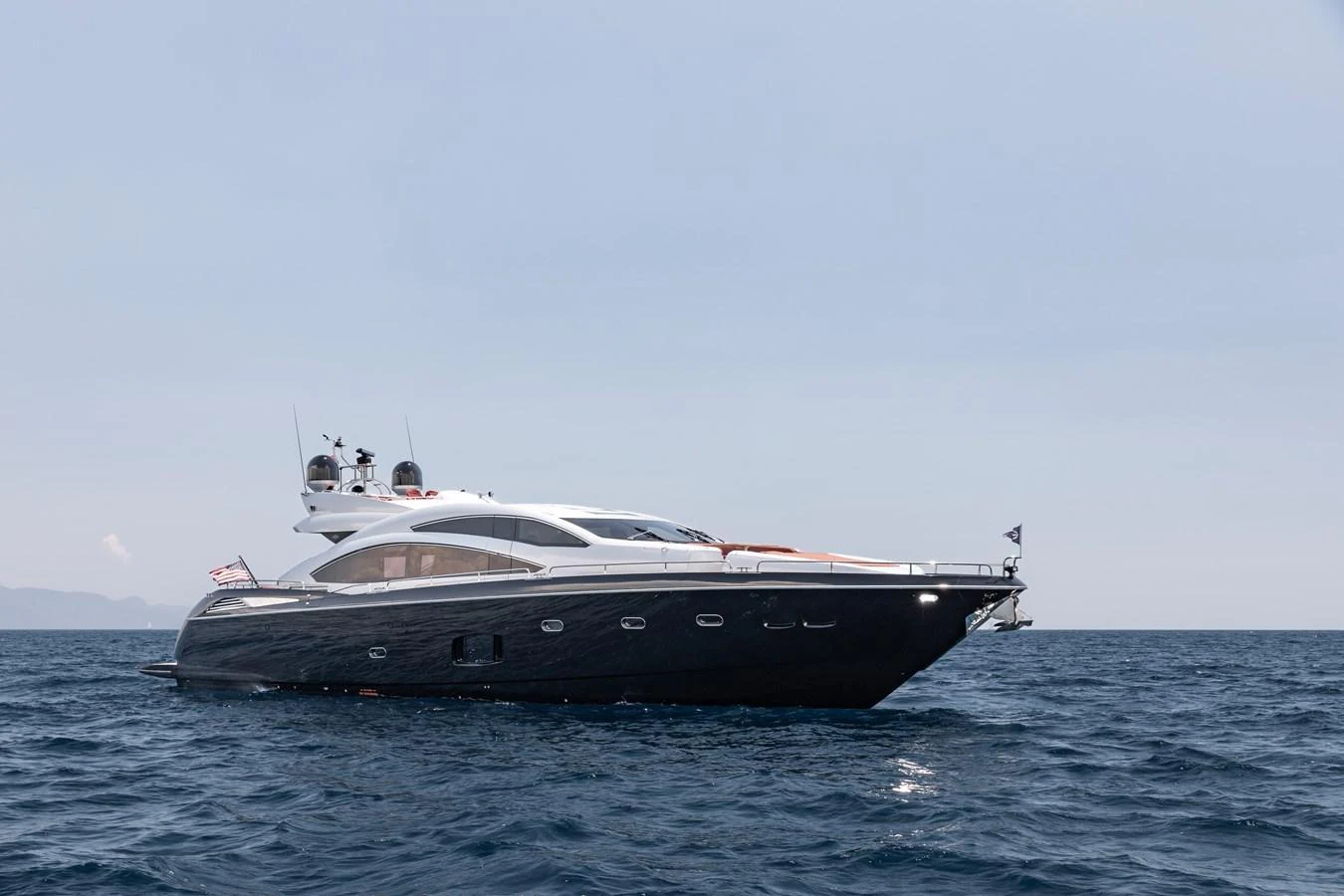 A sleek and modern yacht cruising on open waters under a clear sky. aboard AMARA Yacht for Sale