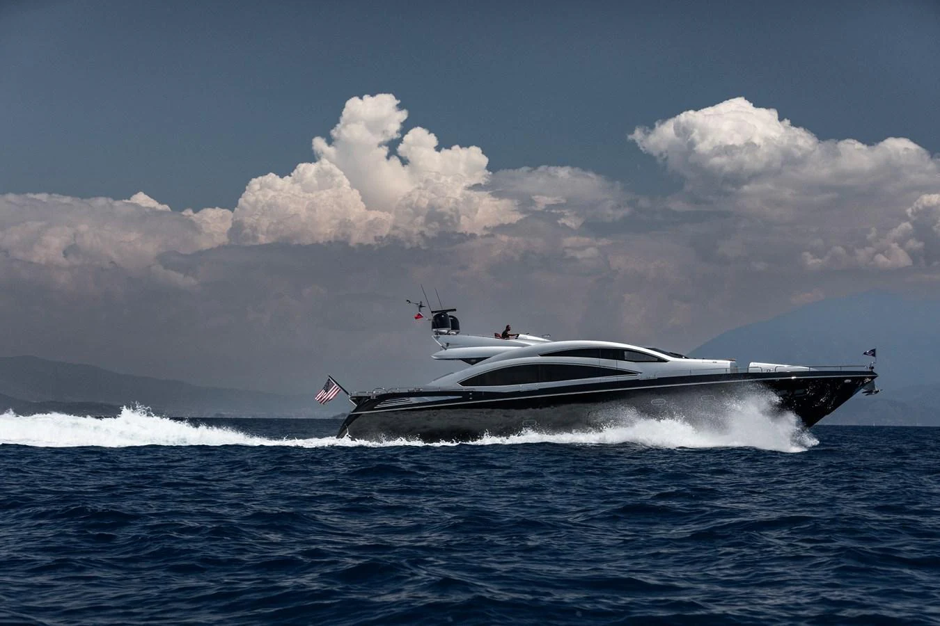 A sleek yacht cruises swiftly through the open sea under a dramatic sky. aboard AMARA Yacht for Sale