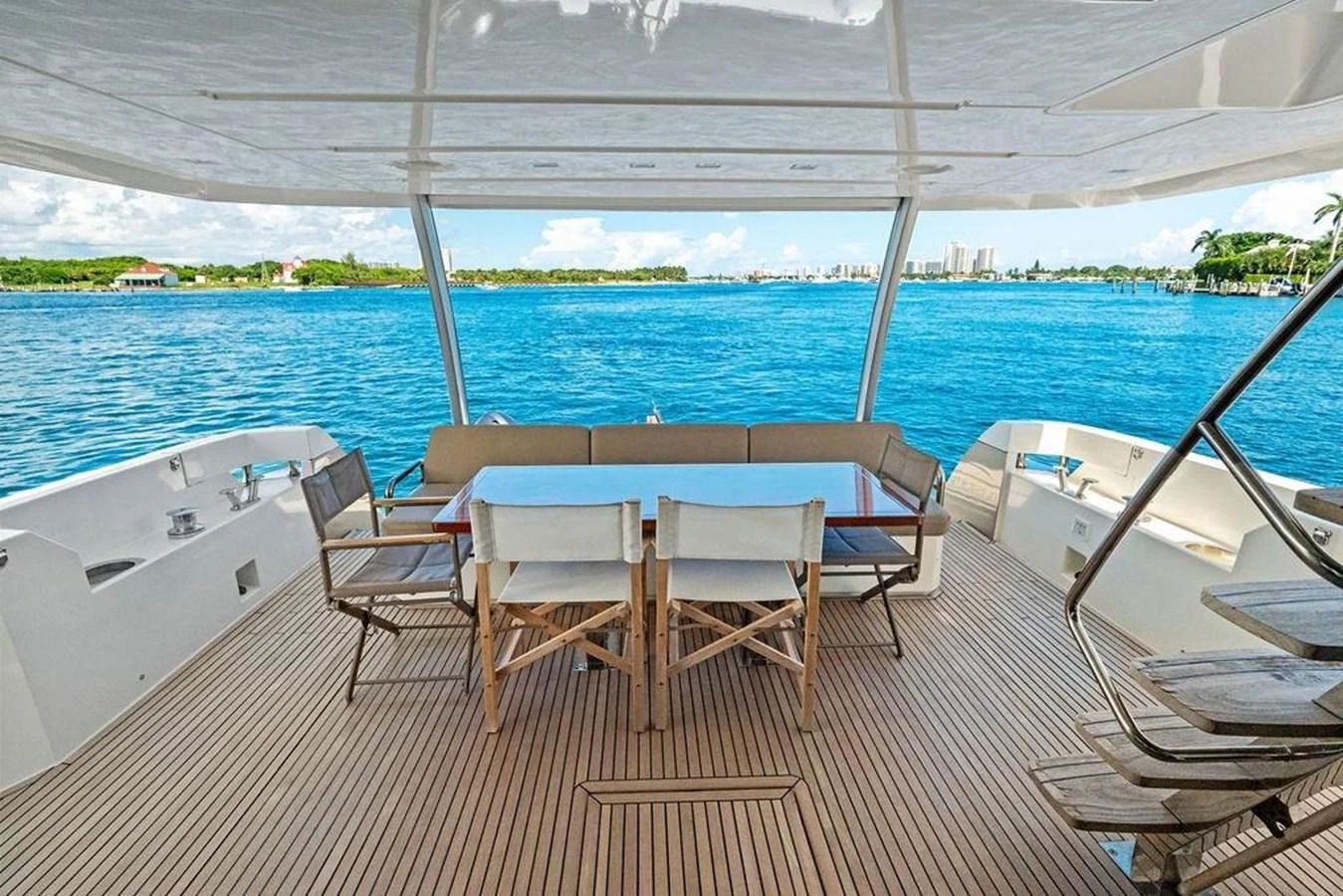 a group of tables and chairs on a deck overlooking a body of water aboard ELEVATION Yacht for Sale