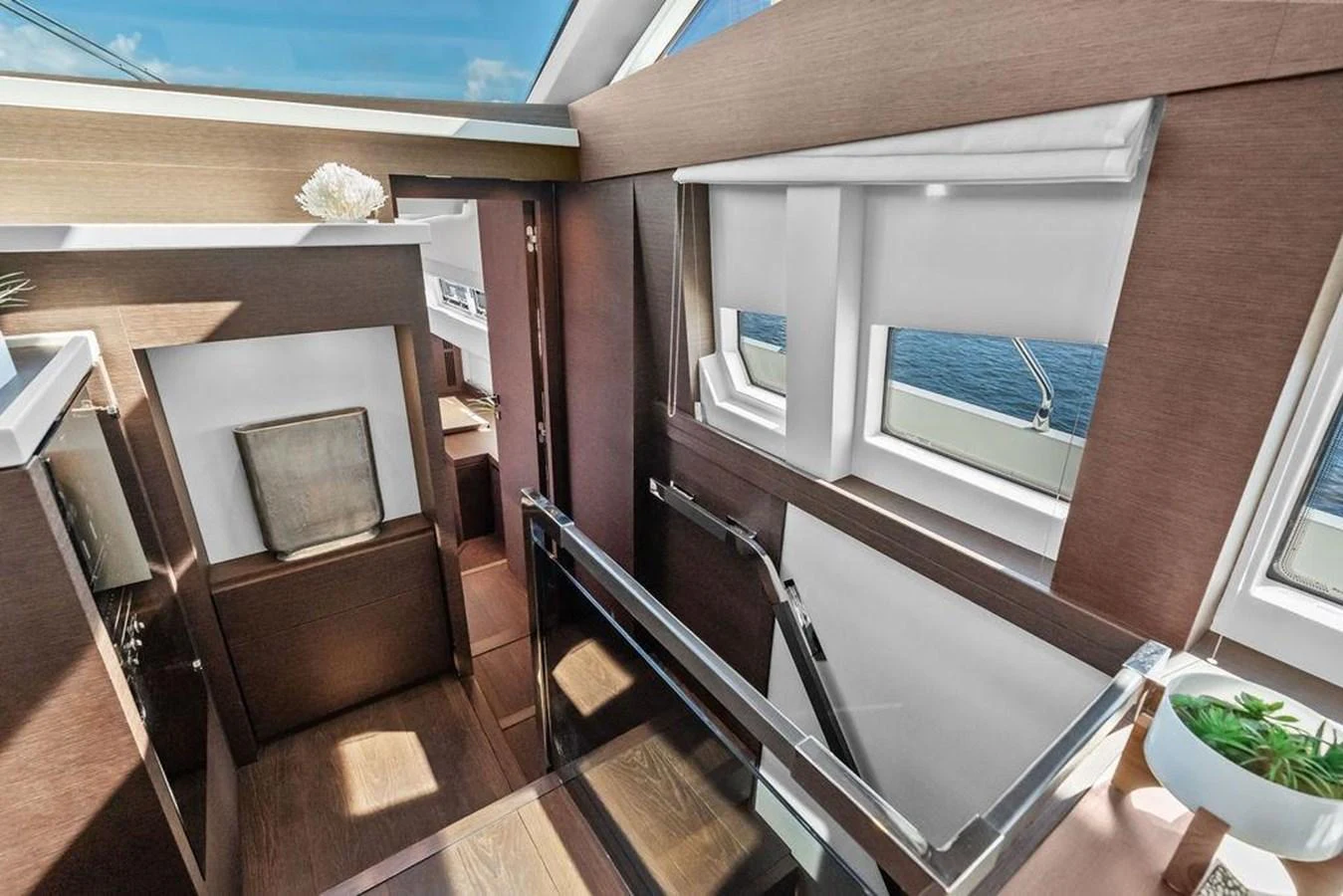 a wood deck with a chair and a door with a balcony aboard ELEVATION Yacht for Sale