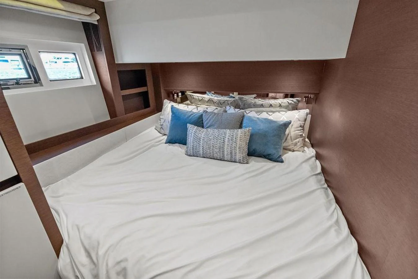 a bed with a white comforter and pillows aboard ELEVATION Yacht for Sale