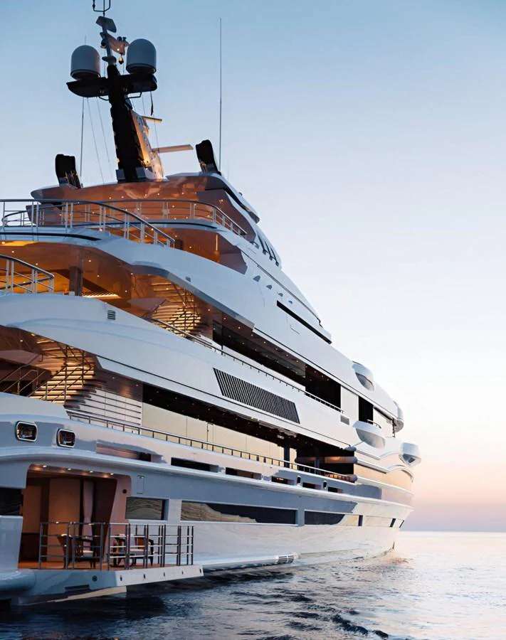 A luxurious yacht glides through the water at sunset, showcasing its sleek design and multiple decks. aboard LANA Yacht for Sale