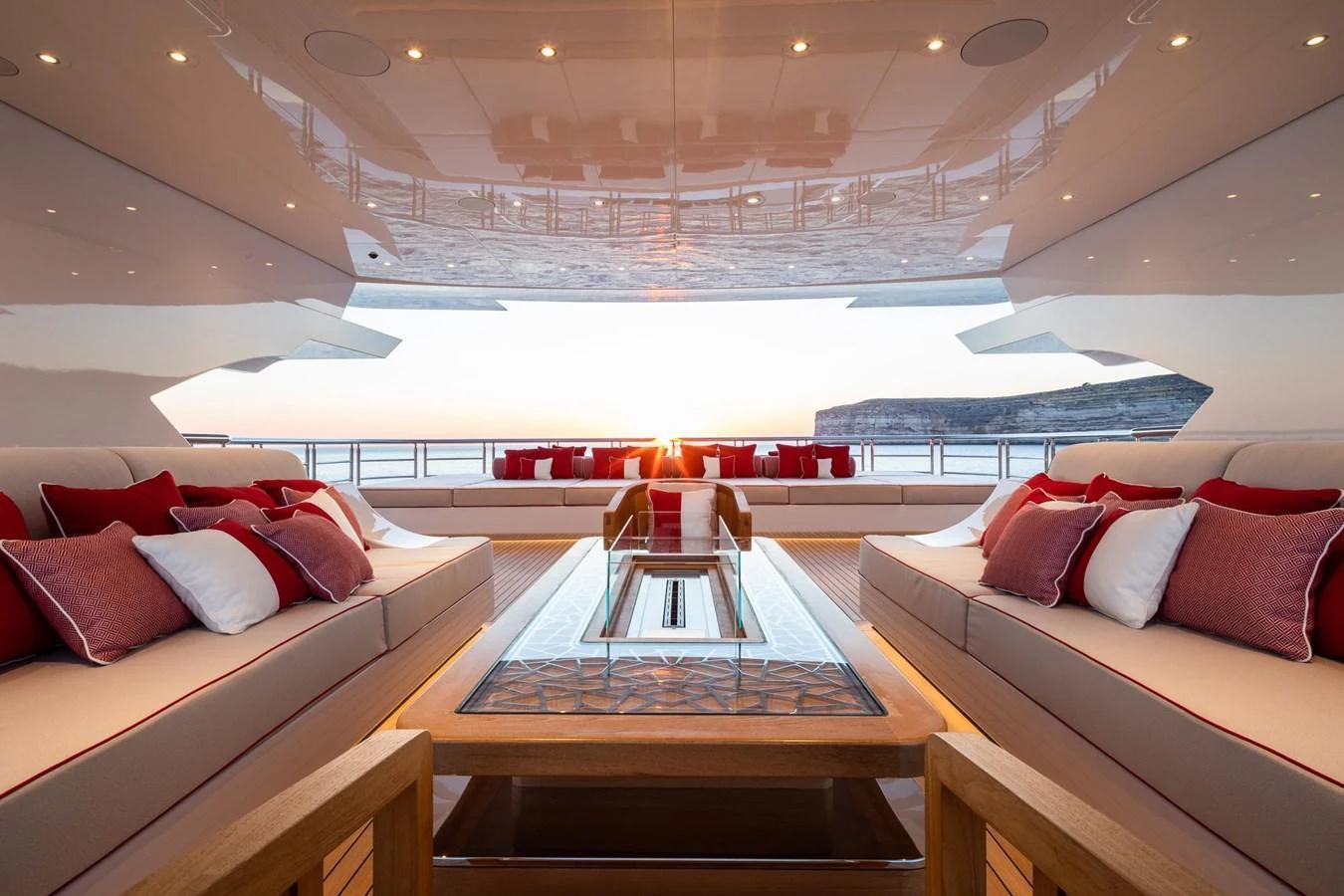 The aft deck offers a luxurious seating area with a stunning view of the sunset over the water. aboard LANA Yacht for Sale