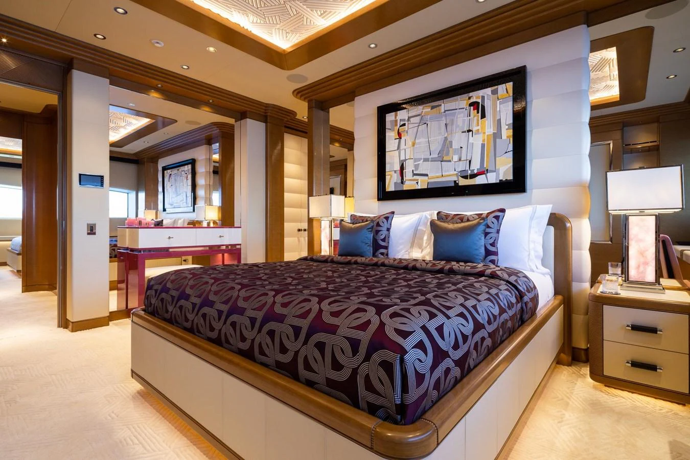The master stateroom features a luxurious bed with elegant decor and modern artwork. aboard LANA Yacht for Sale