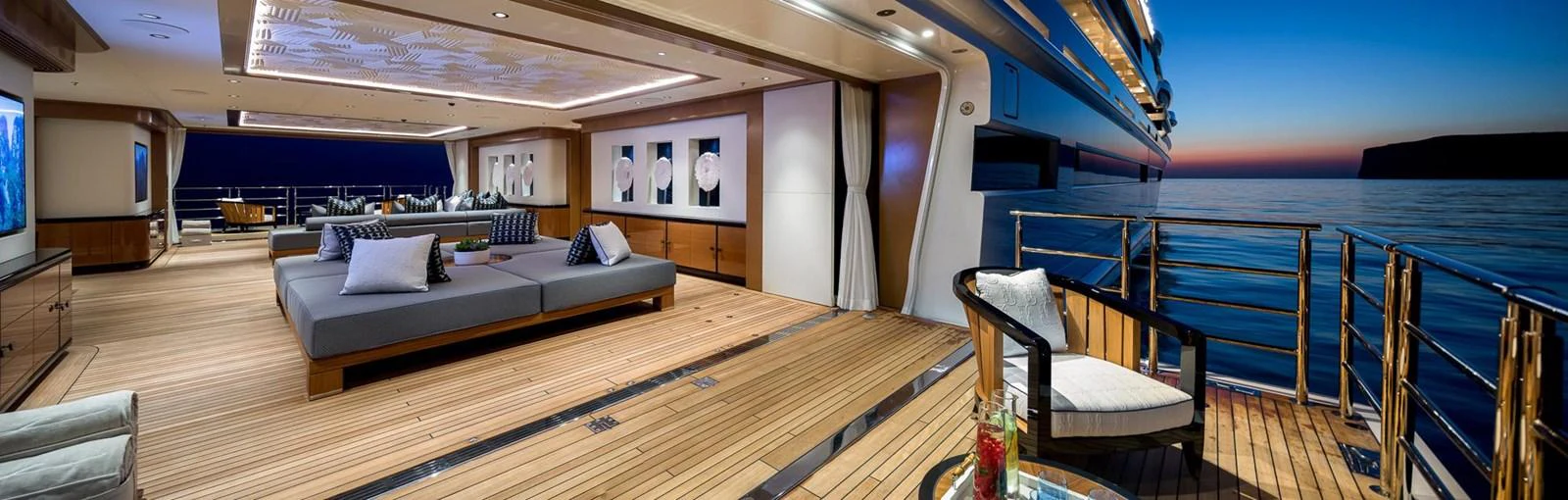 The aft deck offers a luxurious outdoor lounging area with stunning ocean views at sunset. aboard LANA Yacht for Sale