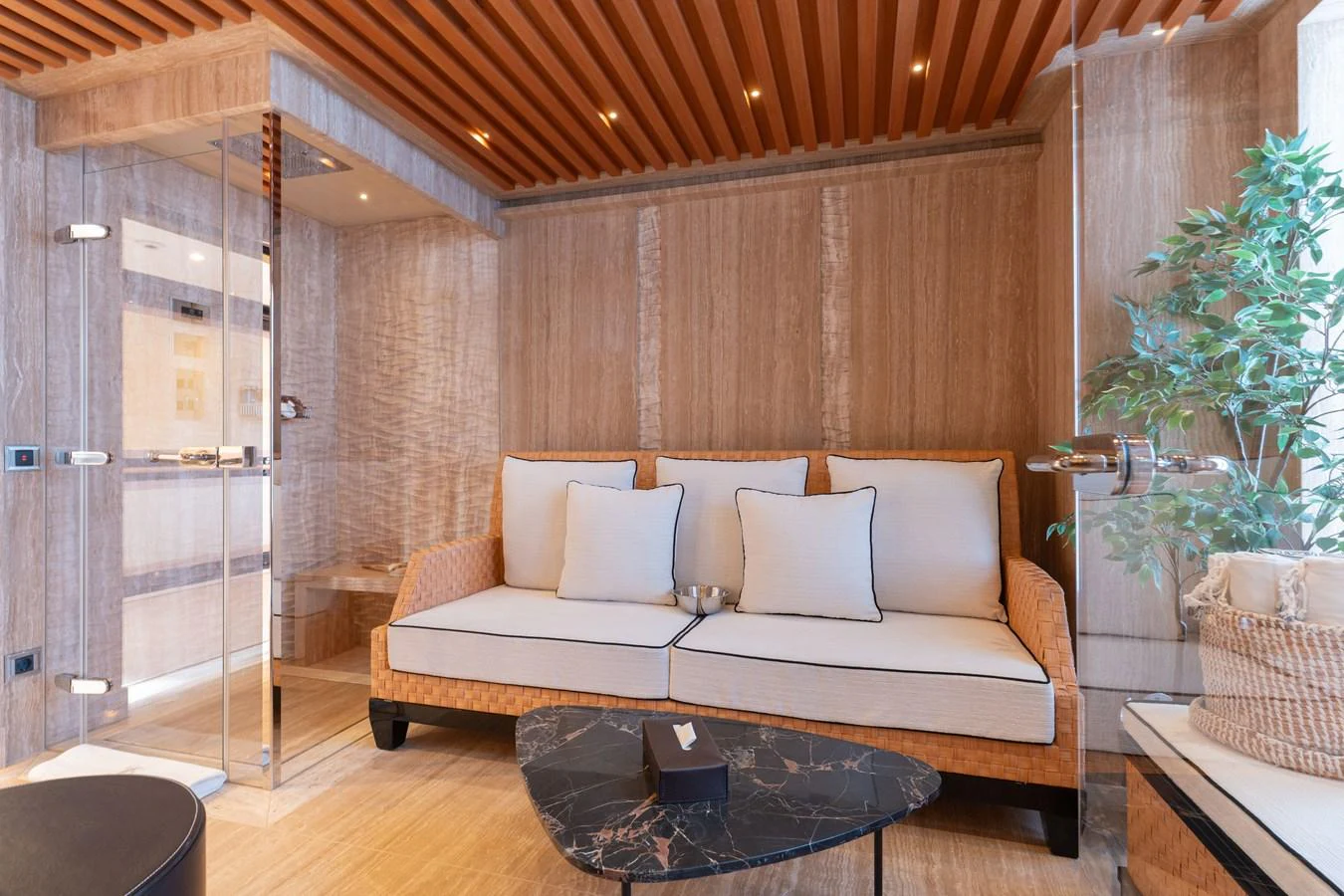 The salon features a cozy seating area with elegant wooden accents and a modern glass door. aboard I DYNASTY Yacht for Sale