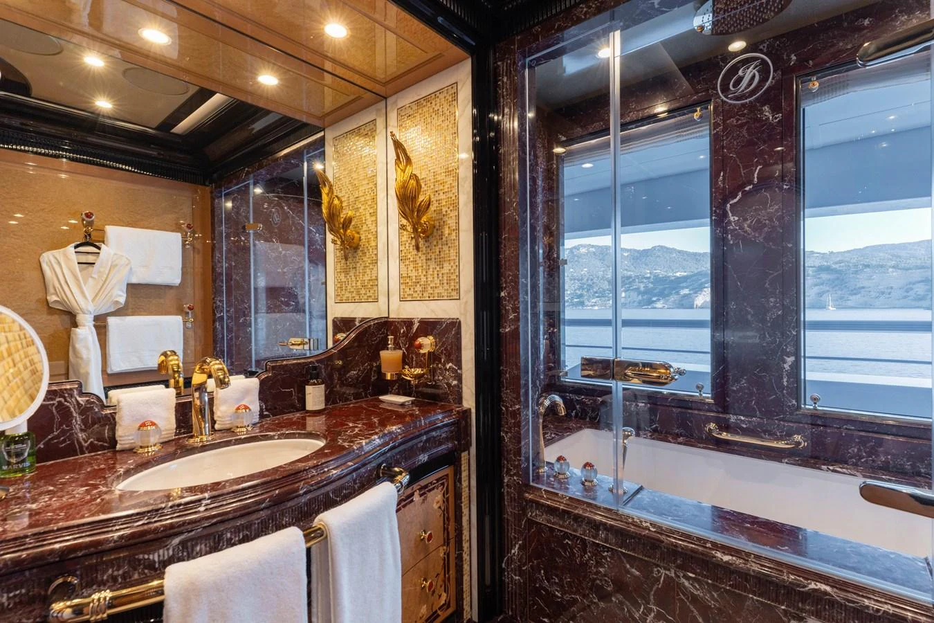 The luxurious bathroom features elegant marble surfaces and a large window with a scenic view. aboard I DYNASTY Yacht for Sale