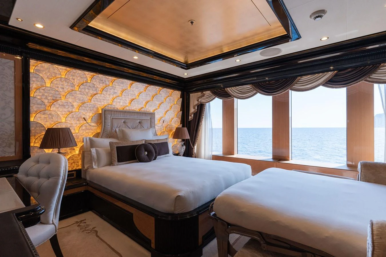 A luxurious stateroom with twin beds and a stunning ocean view through large windows. aboard I DYNASTY Yacht for Sale