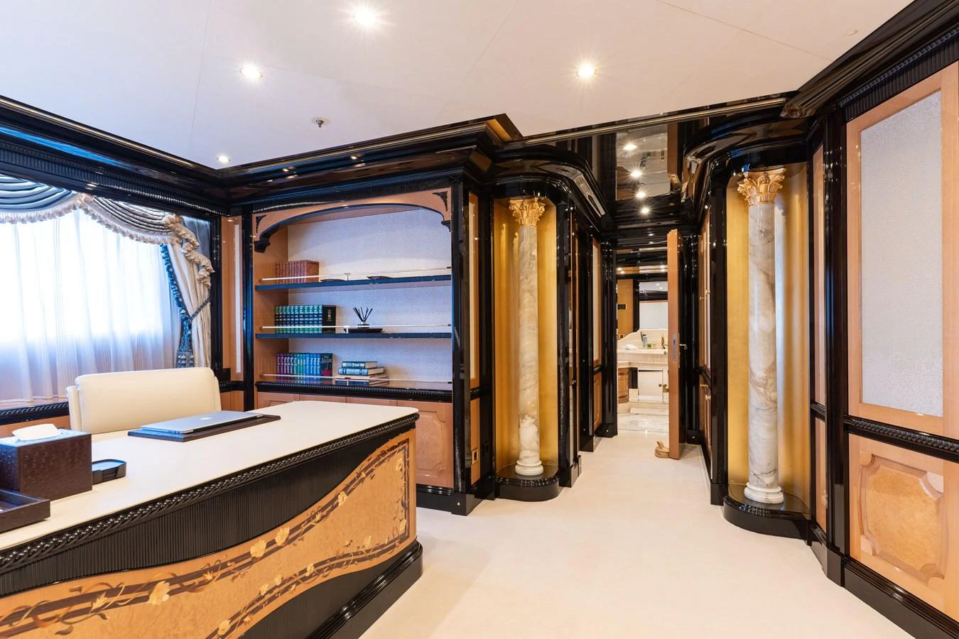 The yacht's office features elegant woodwork, built-in bookshelves, and luxurious furnishings. aboard I DYNASTY Yacht for Sale