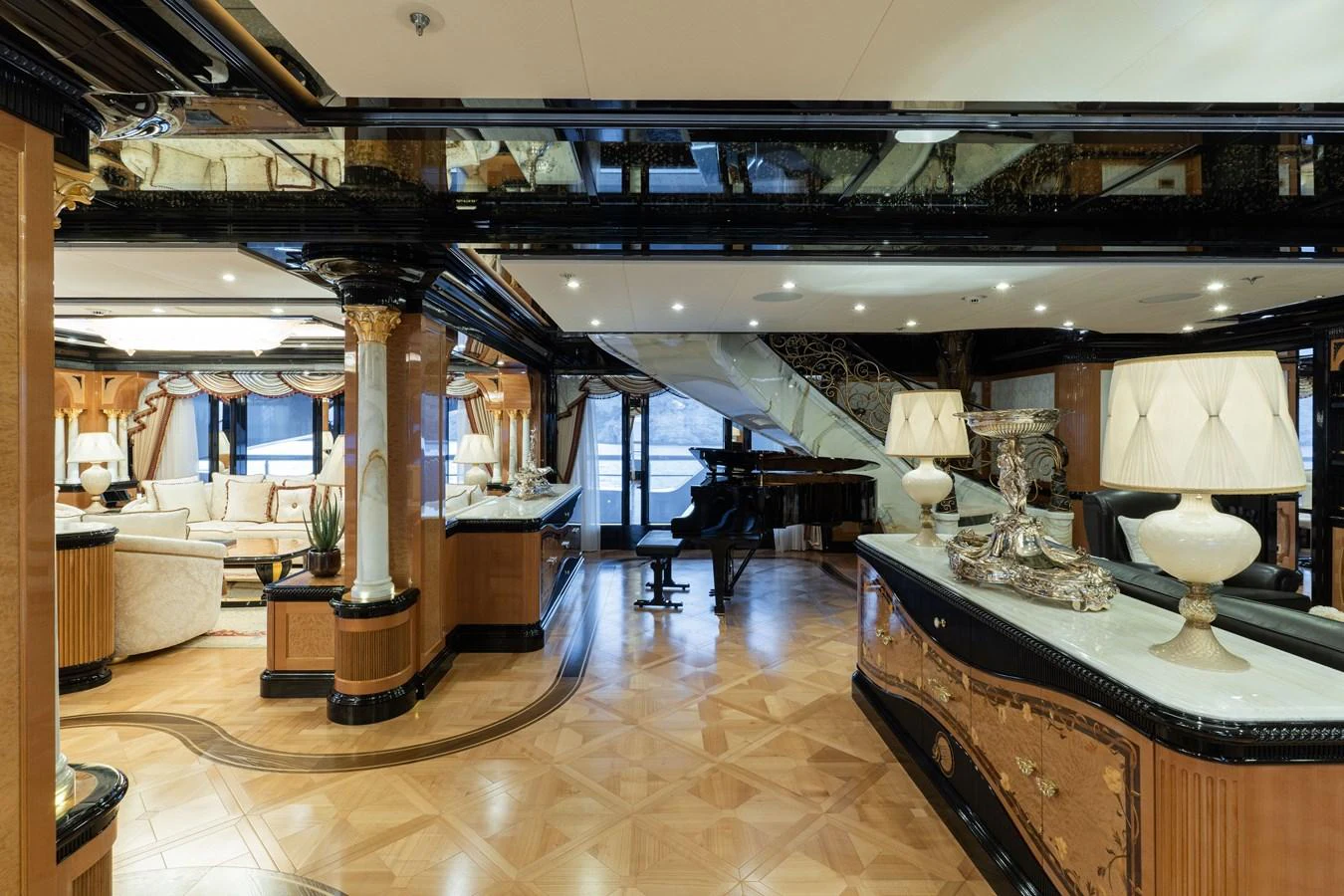 The yacht's interior features an elegant and spacious living area with luxurious furnishings and a grand piano. aboard I DYNASTY Yacht for Sale
