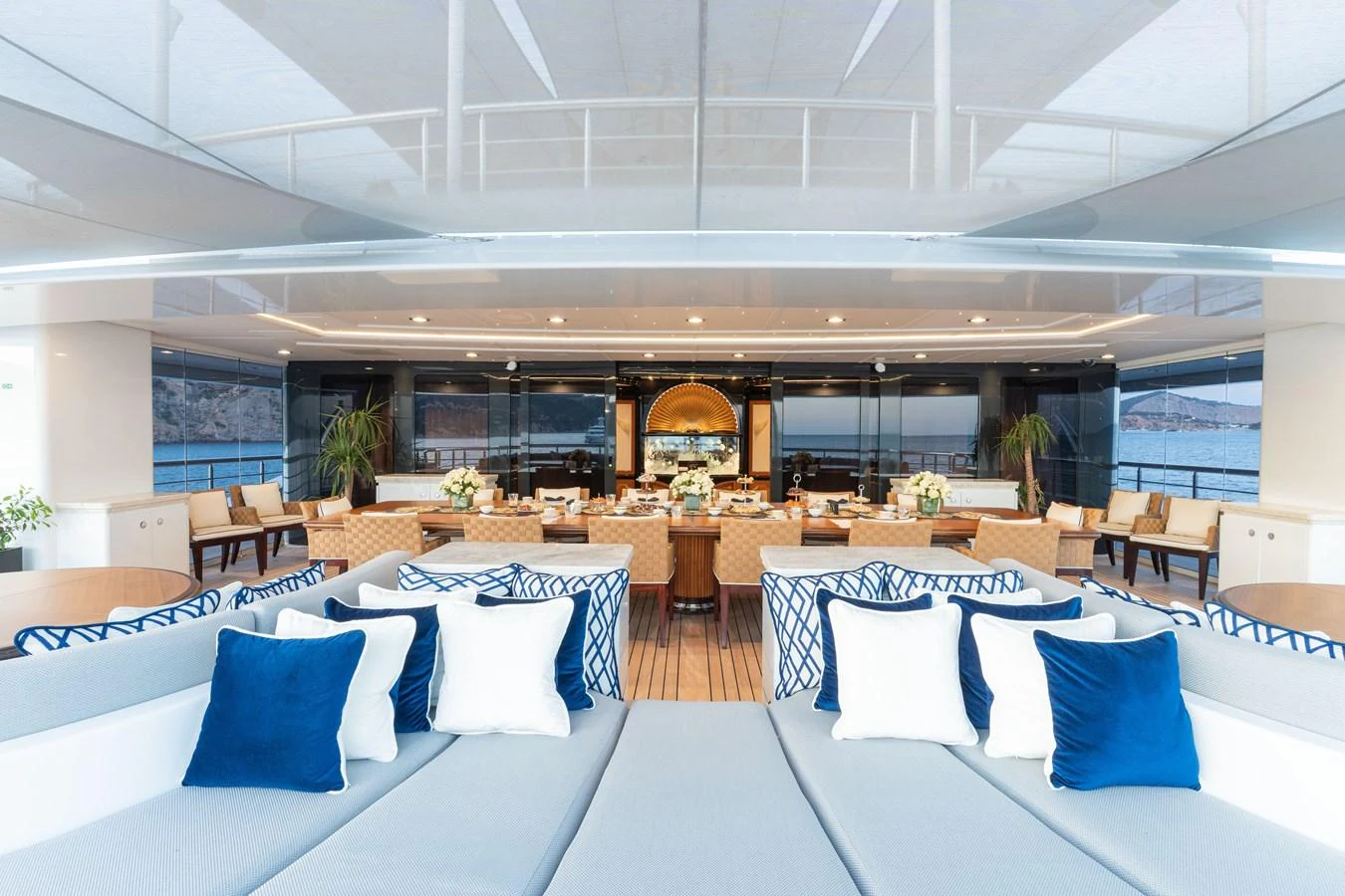 The aft deck features luxurious seating with a view of the dining area and the sea beyond. aboard I DYNASTY Yacht for Sale