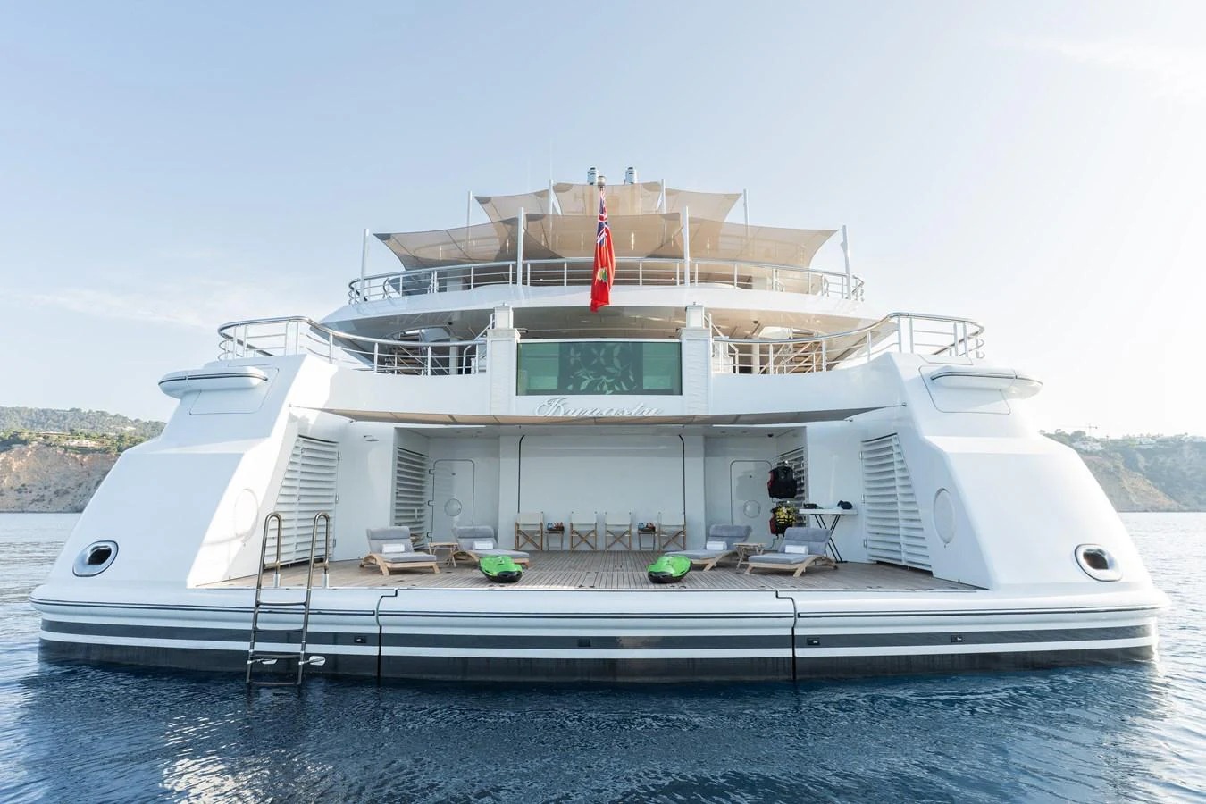 The yacht's aft deck features a spacious lounging area with direct access to the water. aboard I DYNASTY Yacht for Sale