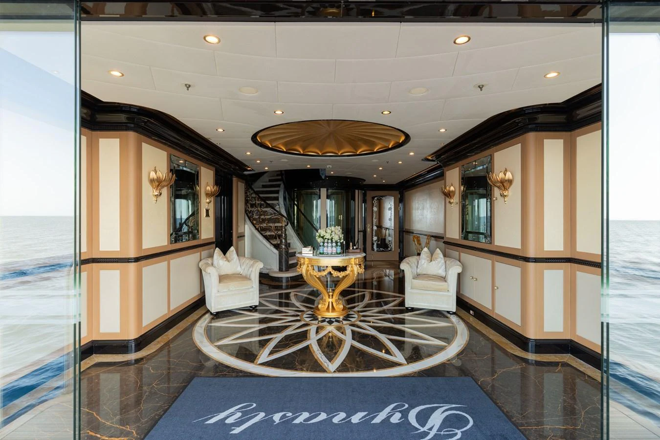 The opulent interior features a grand entrance with luxurious seating and intricate design elements. aboard I DYNASTY Yacht for Sale