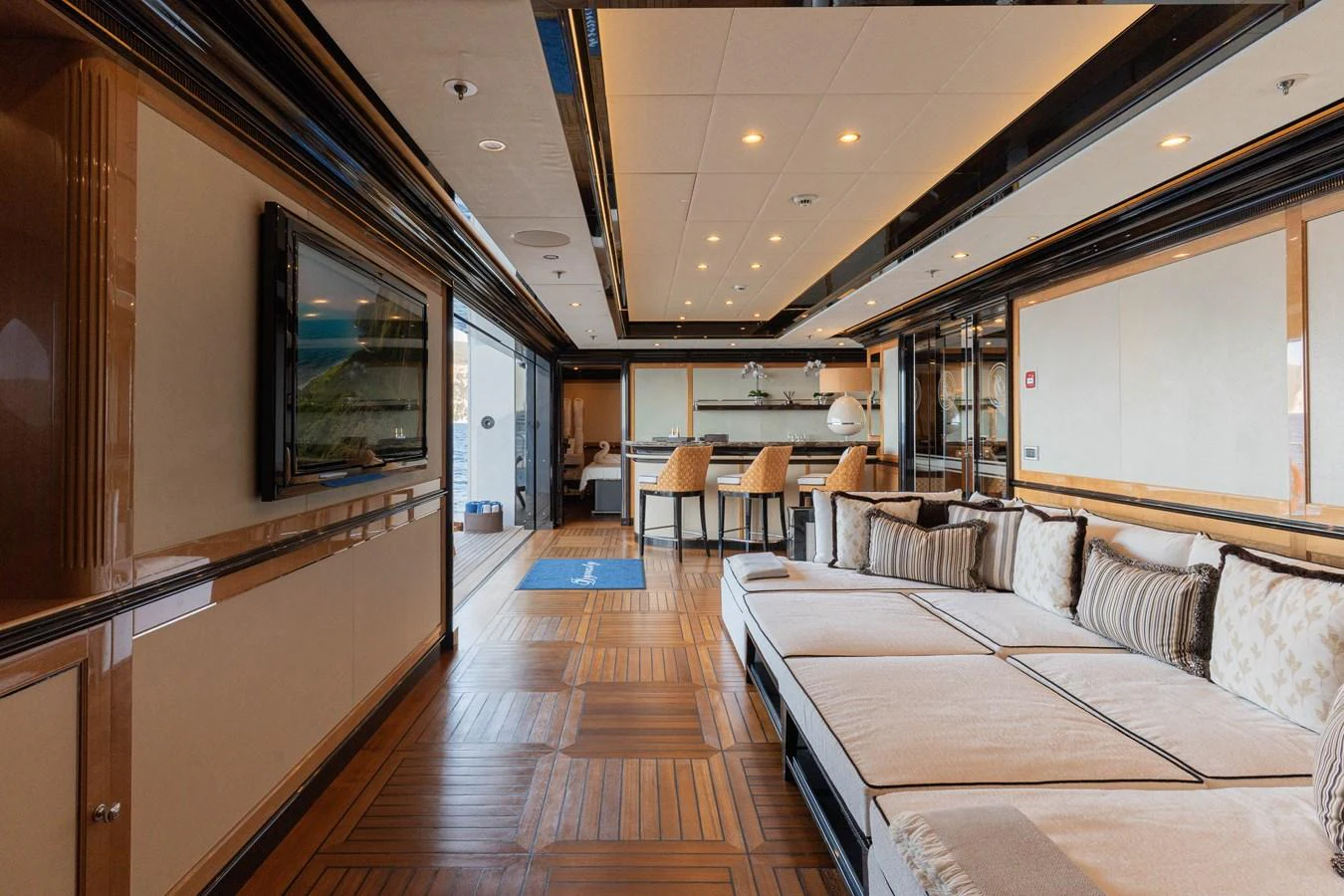 The yacht's salon features luxurious seating and a sophisticated entertainment area with a view towards the galley. aboard I DYNASTY Yacht for Sale