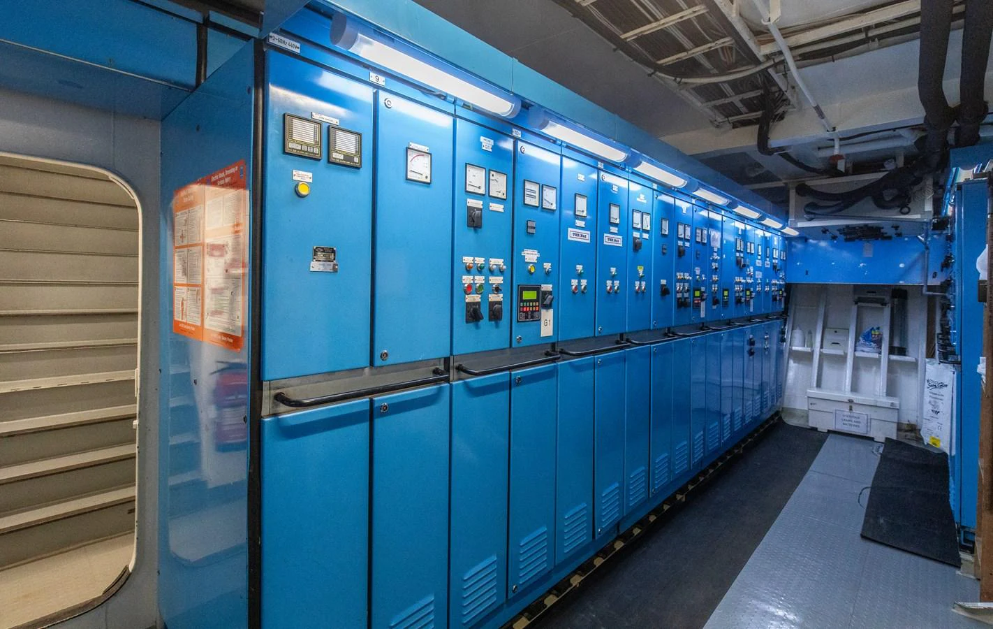 The image showcases the technical control room of the yacht, featuring an array of blue control panels and equipment. aboard SKY Yacht for Sale