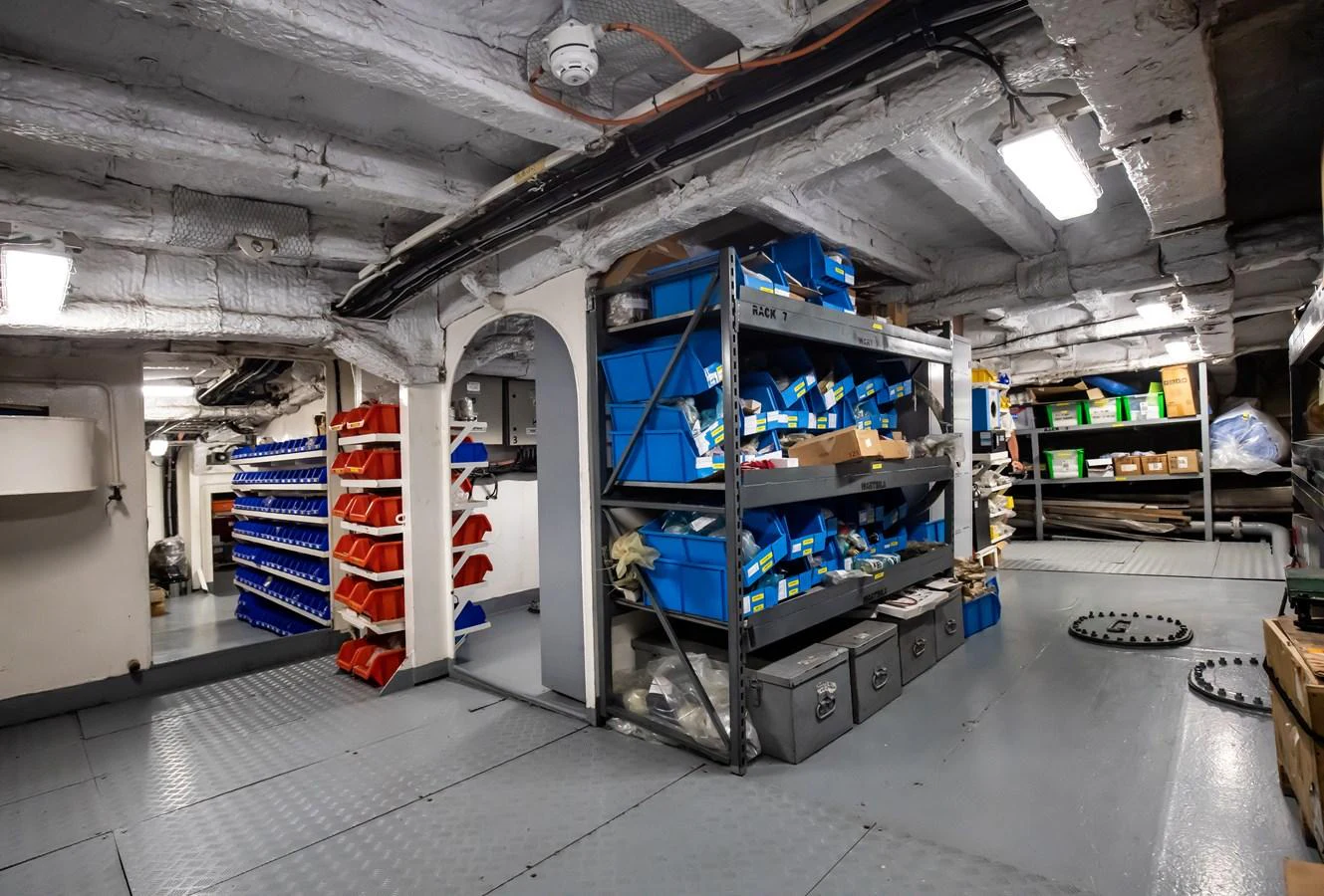 The image shows a well-organized storage area with shelves and bins filled with various supplies and tools. aboard SKY Yacht for Sale