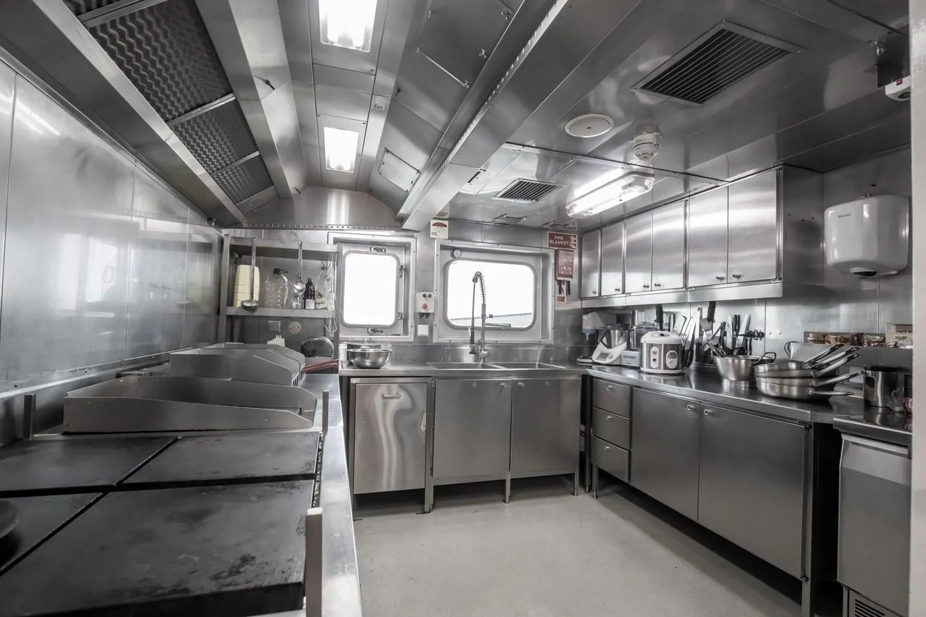 The yacht's galley features a professional-grade stainless steel kitchen with ample counter space and modern appliances. aboard SKY Yacht for Sale