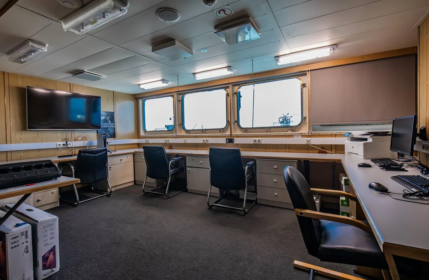 The yacht's office space is equipped with multiple workstations, comfortable seating, and large windows for natural light. aboard SKY Yacht for Sale