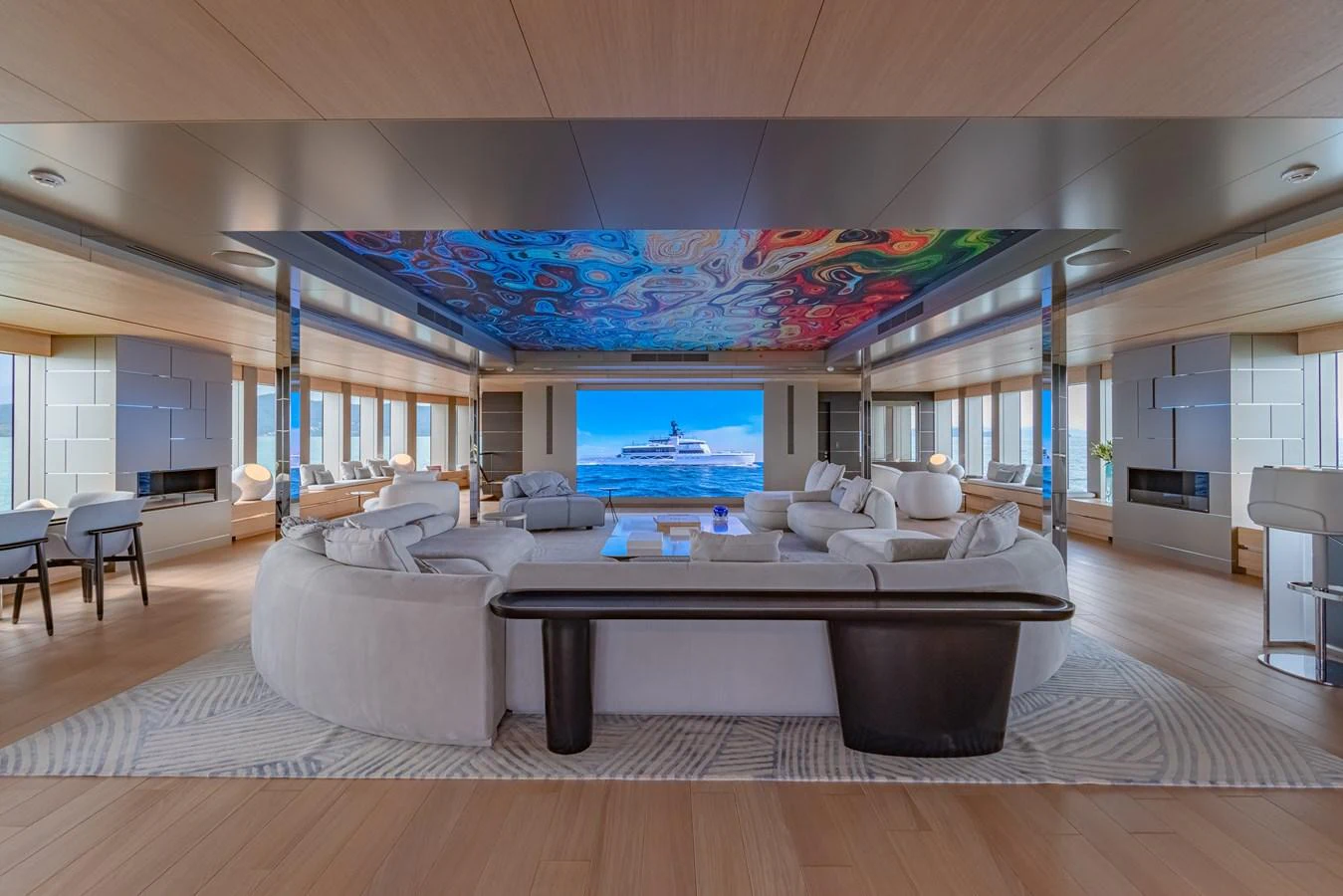 The yacht's salon features luxurious seating with a vibrant ceiling mural and expansive windows offering panoramic views. aboard WANDERLUST Yacht for Sale