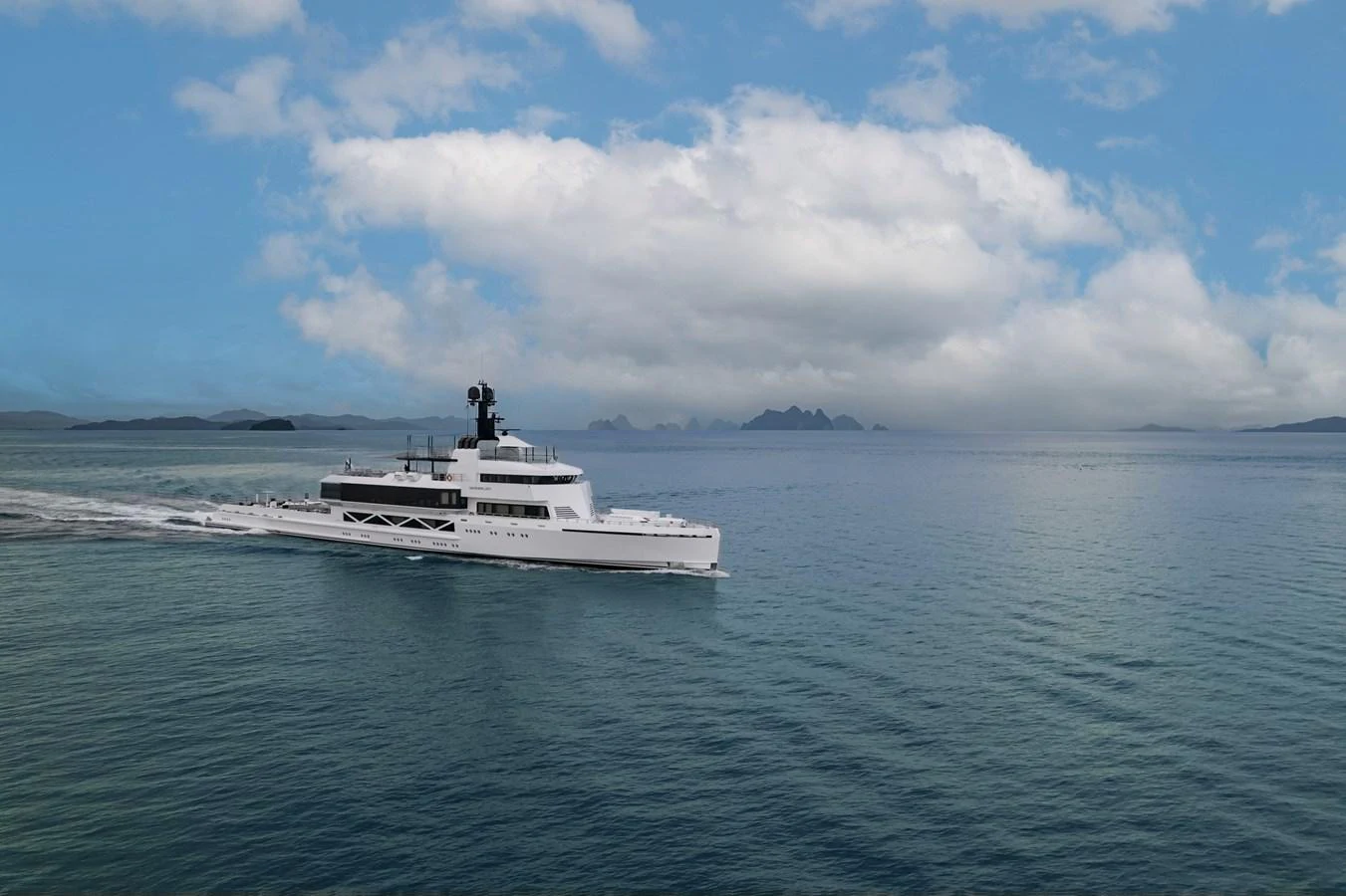 A sleek, modern yacht glides through calm waters under a partly cloudy sky. aboard WANDERLUST Yacht for Sale