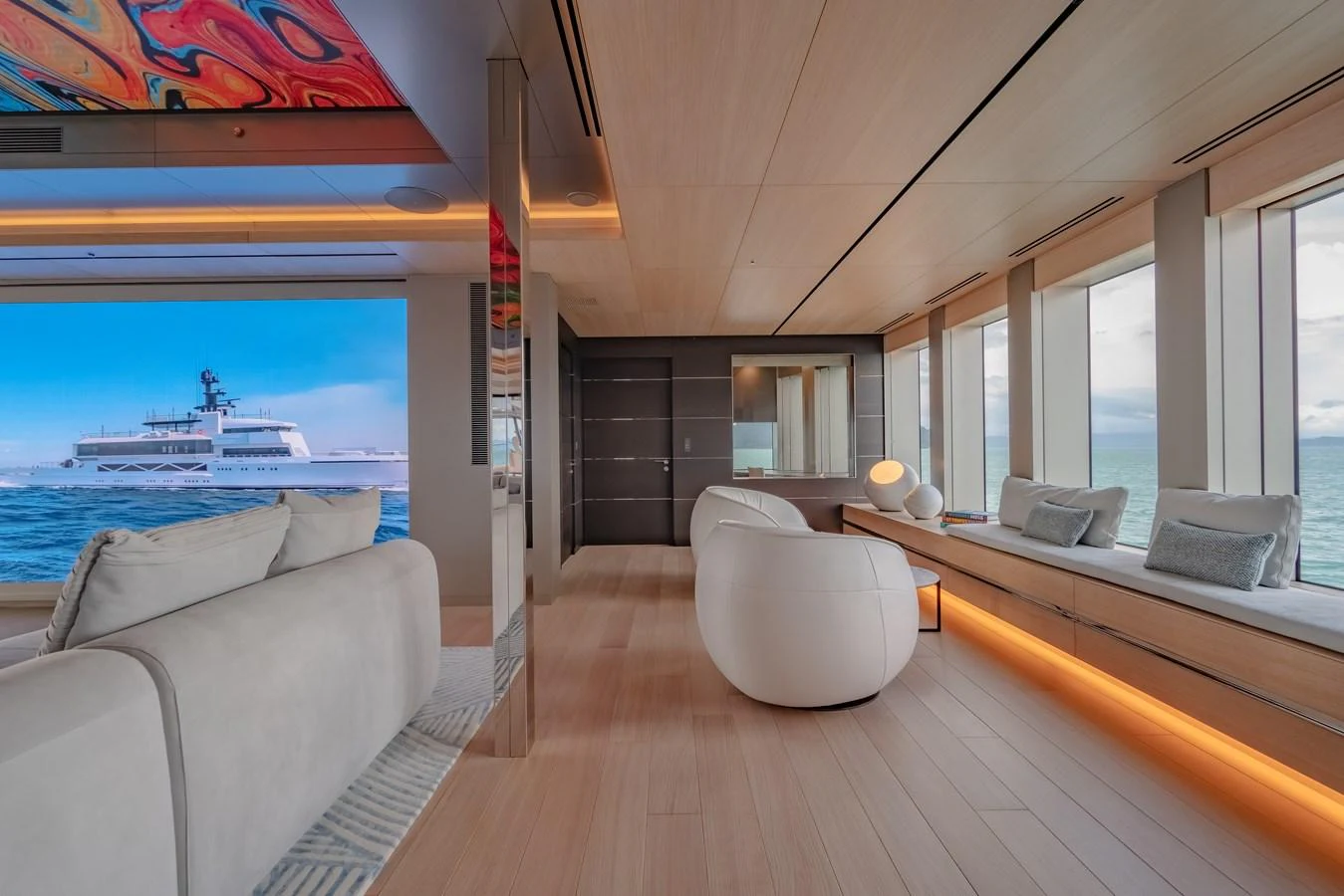The salon features modern furnishings with panoramic windows offering stunning ocean views. aboard WANDERLUST Yacht for Sale