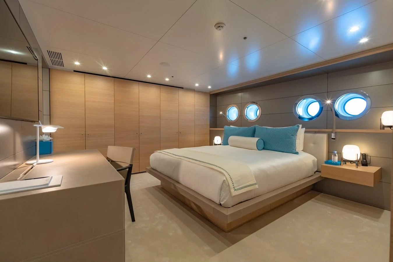 The stateroom features a luxurious bed with elegant lighting and ample storage space. aboard WANDERLUST Yacht for Sale