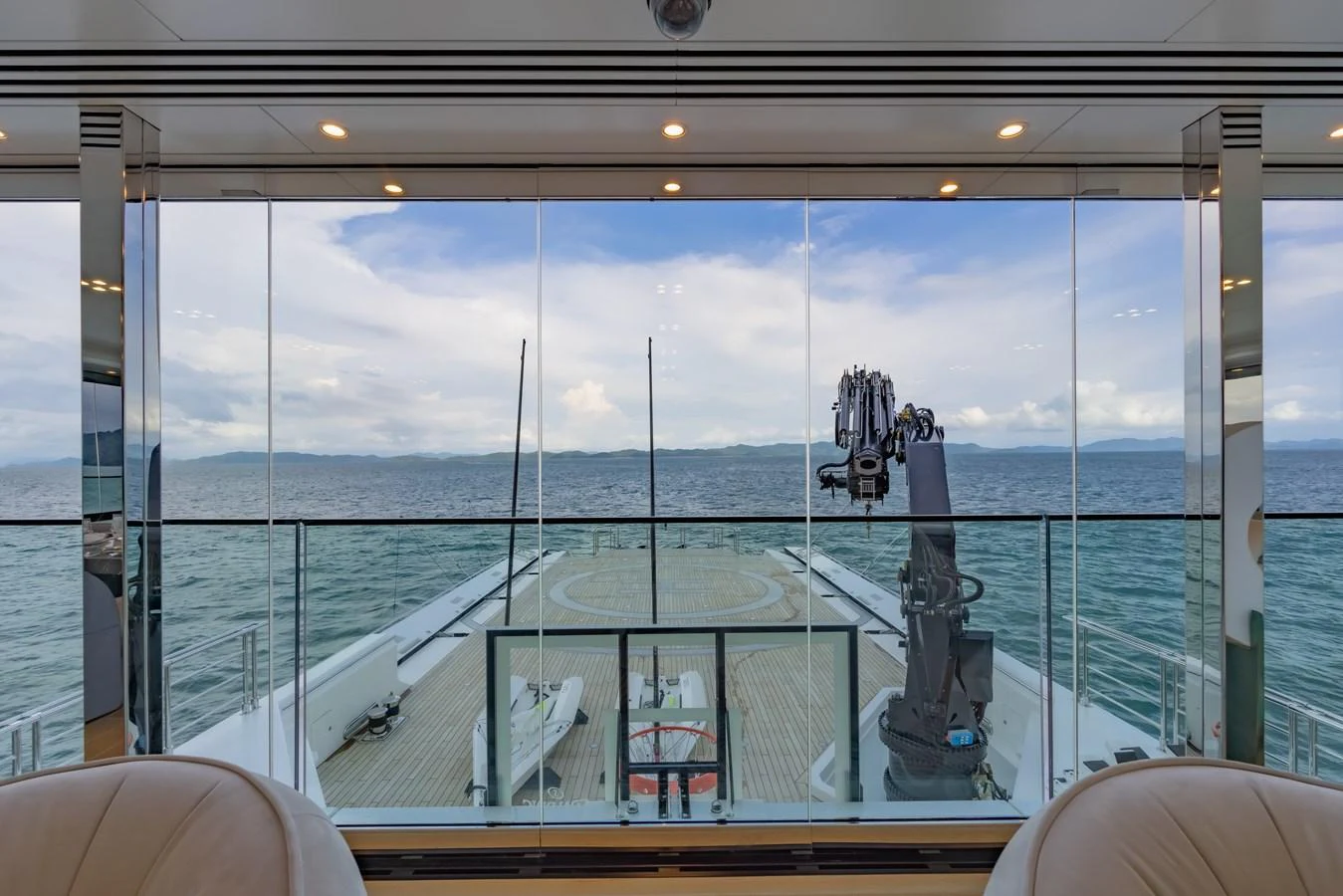 The image showcases the view from the interior looking out onto the aft deck, featuring a serene ocean backdrop. aboard WANDERLUST Yacht for Sale