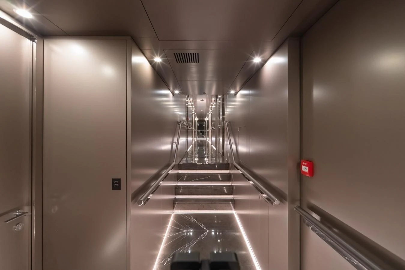 A sleek and modern hallway with ambient lighting and reflective surfaces. aboard WANDERLUST Yacht for Sale