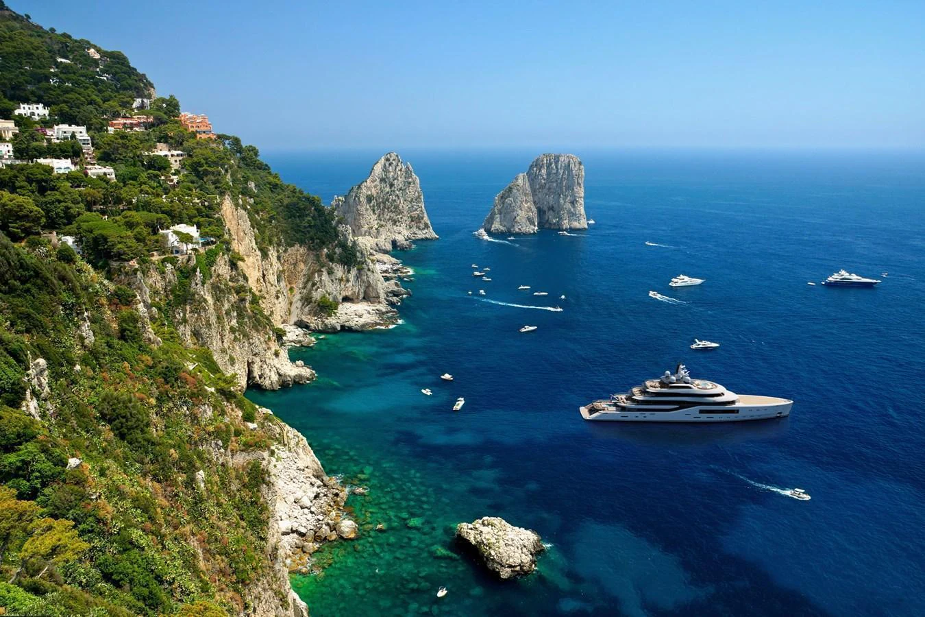 A luxurious yacht cruises along a stunning coastal landscape with clear blue waters and rocky cliffs. aboard AMELS 80 Yacht for Sale
