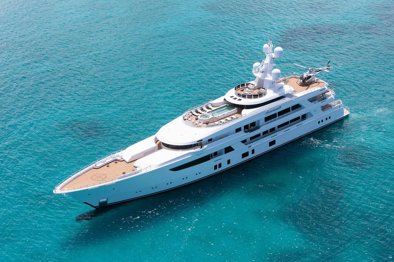 A luxurious yacht cruising on crystal-clear turquoise waters, showcasing its sleek design and expansive decks. aboard BOARDWALK V Yacht for Sale