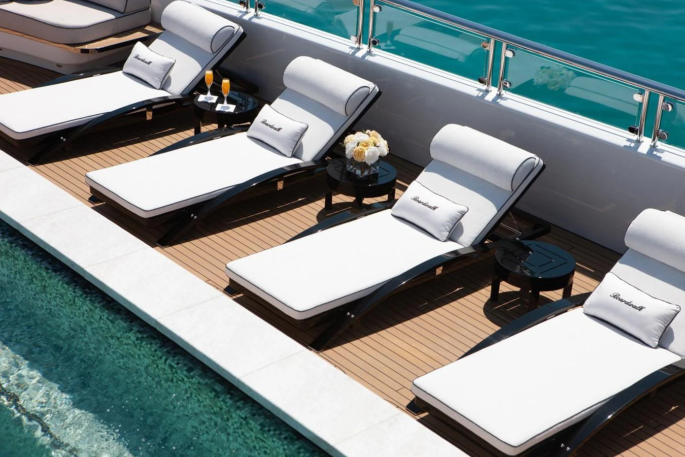 The sundeck features luxurious sun loungers beside a serene pool, perfect for relaxation. aboard BOARDWALK V Yacht for Sale