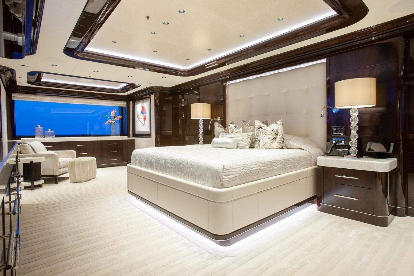 The master stateroom features a luxurious bed, elegant lighting, and expansive windows offering a serene ambiance. aboard BOARDWALK V Yacht for Sale