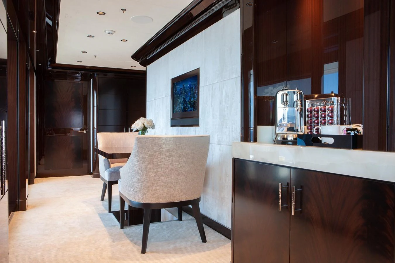 The yacht's interior features a cozy dining area with elegant furnishings and a modern coffee station. aboard BOARDWALK V Yacht for Sale
