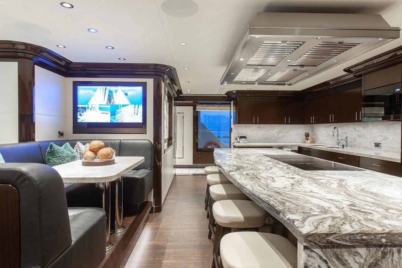 The galley features a luxurious marble countertop and a cozy dining nook with plush seating. aboard BOARDWALK V Yacht for Sale