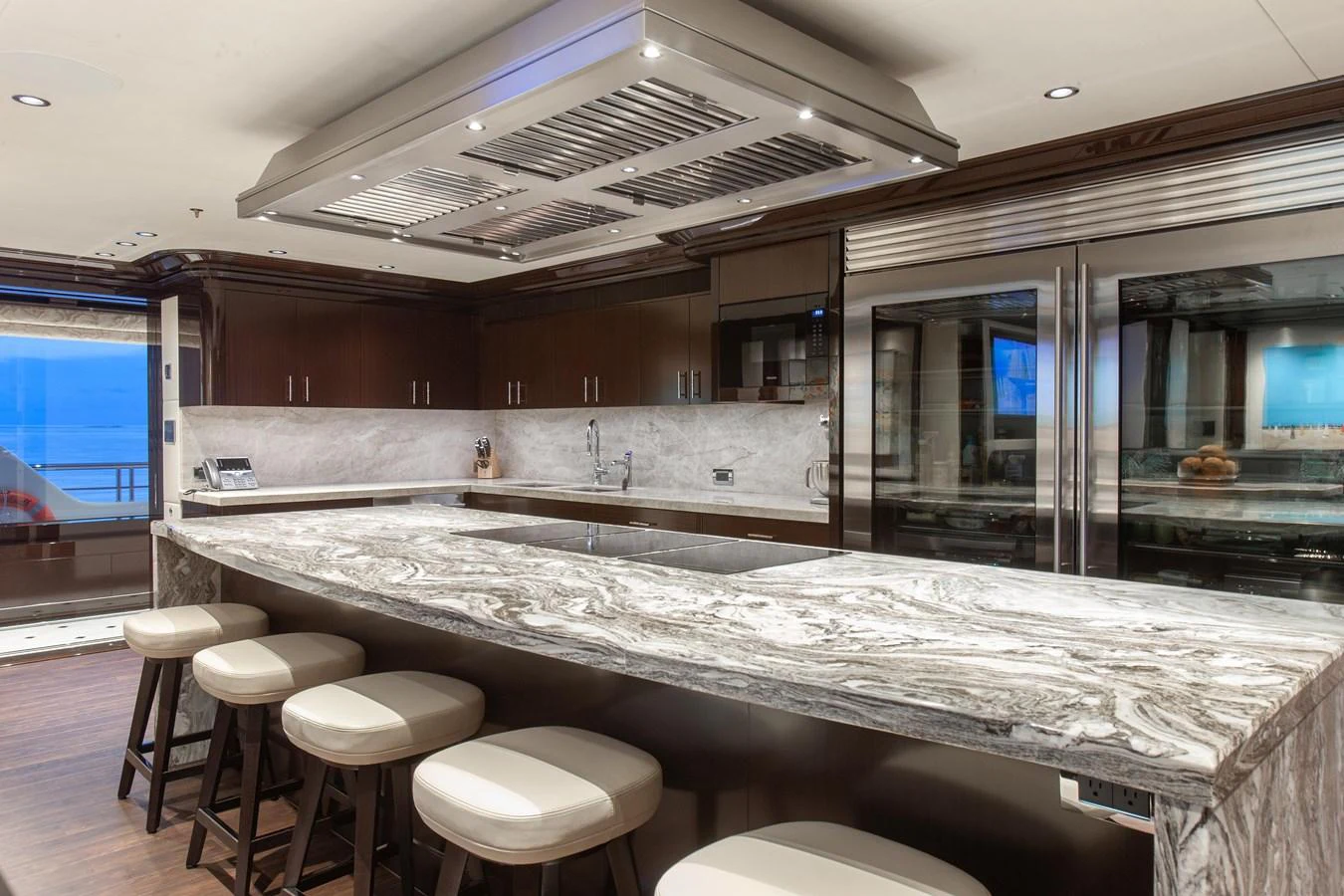 The galley features a luxurious marble countertop with modern appliances and ample seating. aboard BOARDWALK V Yacht for Sale