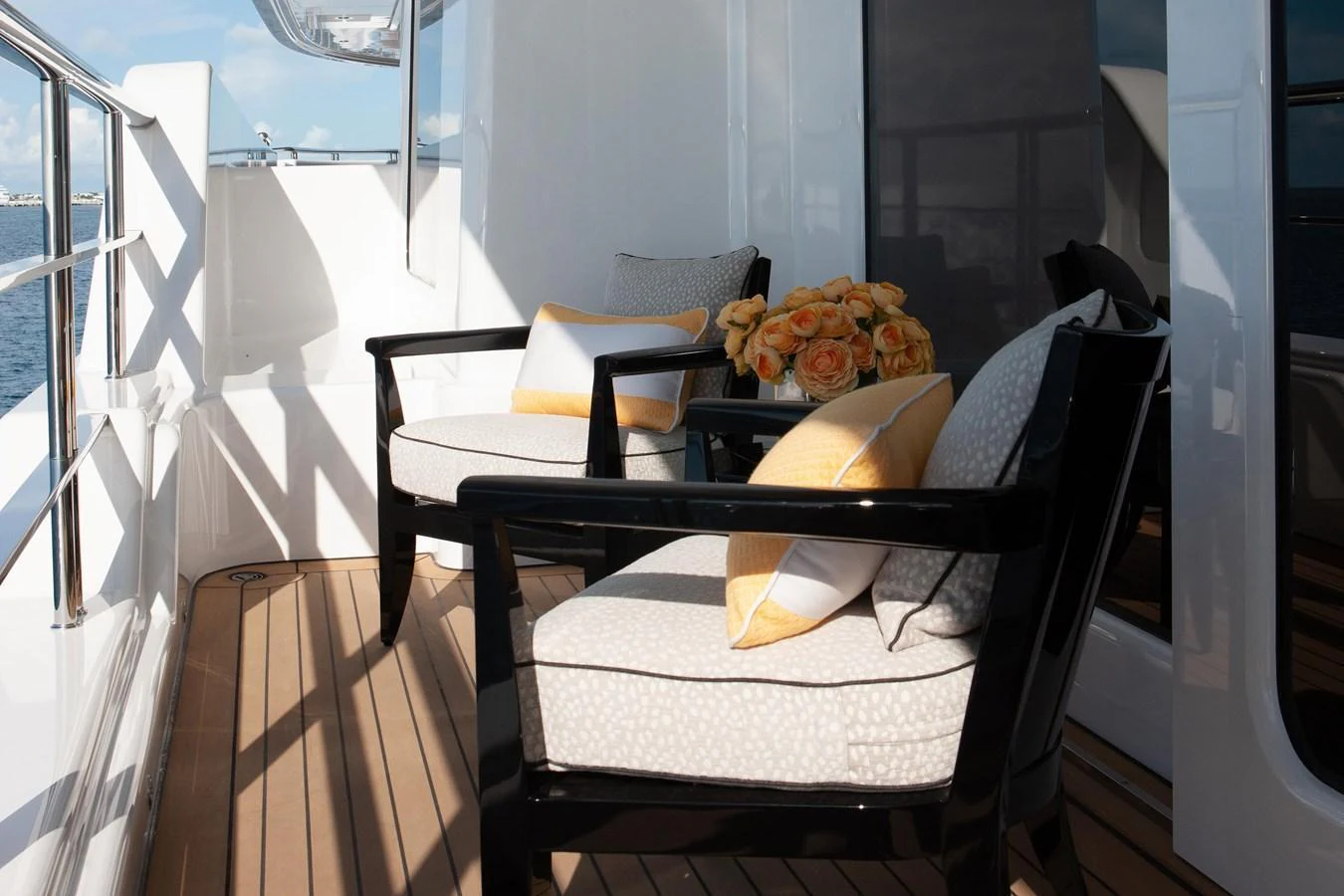 The aft deck features comfortable seating with plush cushions and a stylish floral arrangement. aboard BOARDWALK V Yacht for Sale