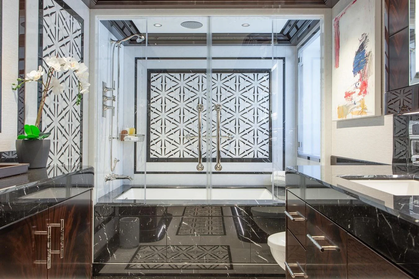 The luxurious bathroom features a modern design with elegant black and white accents. aboard BOARDWALK V Yacht for Sale