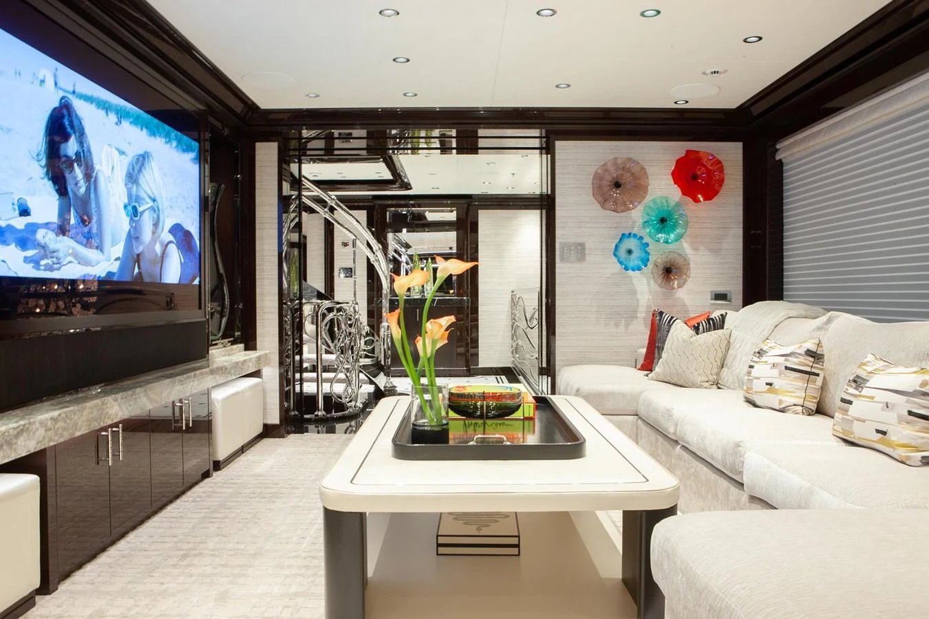 The luxurious interior features a spacious lounge area with a large TV and elegant decor. aboard BOARDWALK V Yacht for Sale